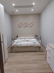 a bedroom with a bed and a white wall at Rusina in Santa Venerina