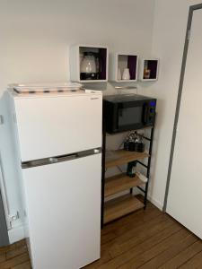 a white refrigerator in a kitchen with a microwave at Logement, idéal famille, amis, tout y est ! in Dompierre-sur-Besbre
