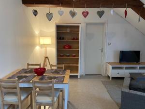 a living room with a table and chairs and a television at Le coeur des VOSGES in Contrexéville