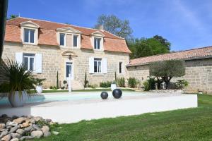 a stone house with a swimming pool in front of it at Domaine de Daspe in Beaupuy
