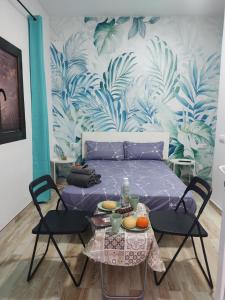 ein Schlafzimmer mit einem Bett und einem Tisch mit Stühlen in der Unterkunft Habitación cactus, entrada privada y baño privado en suite by flamingo house, no fumadores in Arrecife