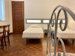 a hospital room with two beds and a window at Casa Às Seis in Angra do Heroísmo