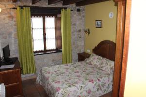 a bedroom with a bed and a tv and windows at La Venta de Quijas in Quijas