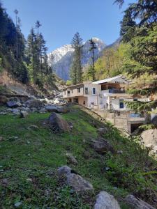 a house on a hill next to a river at Blue Water Resort Kalam in Kārandūkai