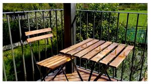 un banc en bois assis à côté d'une clôture métallique dans l'établissement APARTAMENTO HOLIDAYS IN AINSA, à Aínsa