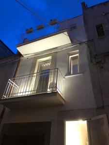 a white building with a balcony at night at Casa Chartù -luxury house- in Conversano