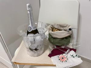 una bottiglia di champagne su un tavolo con un contenitore di cibo di Casa Chartù -luxury house- a Conversano