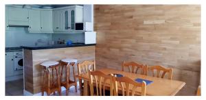 une cuisine et une salle à manger avec une table et des chaises dans l'établissement APARTAMENTO HOLIDAYS IN AINSA, à Aínsa