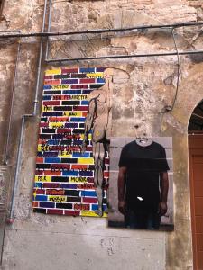 Un uomo in piedi accanto a un muro con un dipinto di Incantevole appartamento centro storico Perugia a Perugia