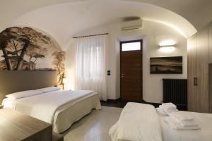 Hotel Ristorante Alla Vittoria في سولفرينو: غرفة فندقية بسريرين ونافذة