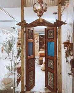 Cette chambre dispose de deux portes en bois et d'un lustre. dans l'établissement Fas BnB, à Jiali