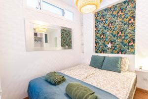 ラスパルマス・デ・グランカナリアにあるApartment Azul Beachのベッドルーム1室(ベッド1台付)が備わります。壁には絵画が飾られています。