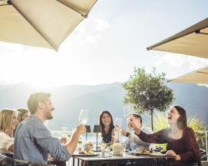 a group of people sitting at a table with wine glasses at Living Eden by we rent, SUMMERCARD INCLUDED in Zell am See