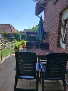 einen Terrassentisch mit einem Sonnenschirm und 2 Stühlen in der Unterkunft Schöne offene Ferienwohnung mit großer Terrasse. in Bad Münder am Deister