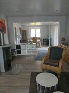 ein Wohnzimmer mit einem Stuhl und einem Tisch in der Unterkunft Schöne offene Ferienwohnung mit großer Terrasse. in Bad Münder am Deister
