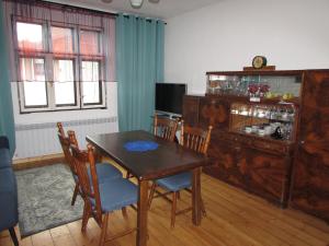 a dining room with a wooden table and chairs at Dům u rybníka in Nýdek