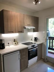 a kitchen with wooden cabinets and a white stove top oven at Apartment Olive & Kin, Collioure in Collioure