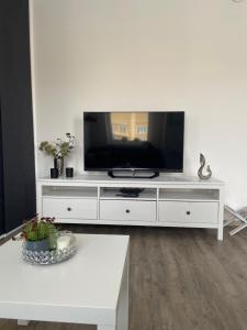 um centro de entretenimento branco com uma televisão de ecrã plano em Wolkerovka Apartment 1 em Olomouc