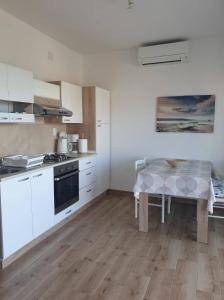 a kitchen with white cabinets and a table in it at Apartment Alice in Novigrad Istria
