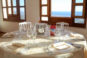 einen Tisch mit einem weißen Tischtuch mit Brille und Besteck in der Unterkunft Albergo Palazzo Sant'Anna in Gerace