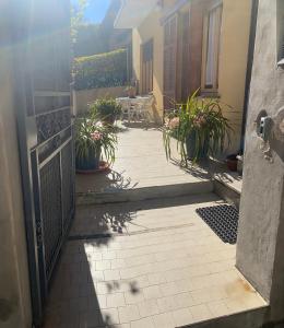 una porta aperta su un patio con piante in vaso di il nido nella quiete a Tremezzo
