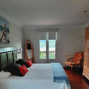 a bedroom with a large bed and a window at Habitaciones Turísticas Ontxene in Busturia