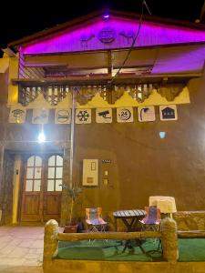 un edificio con luces púrpuras en el lateral. en نُزُل تُراثي شقْراء Heritage Guesthouse Shaqra, en Shaqra