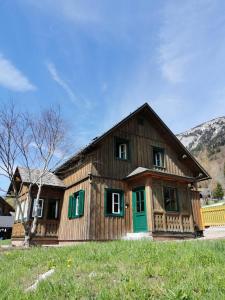 a large wooden house with a green door at Ferienhaus Rosl am Grundlsee in Grundlsee