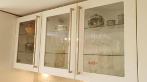 a kitchen cabinet filled with glasses and dishes at Roseford Apartment, Crail in Crail +17 photos
