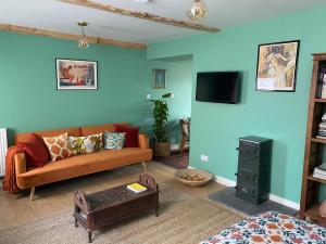 a living room with a couch and a flat screen tv at The Old Chair Workshop in Sedbergh