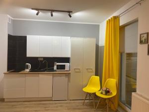 a kitchen with two yellow chairs and a counter at Apartament Karpacz 2- pokojowy in Karpacz