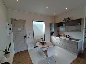 a kitchen with a table and chairs in a room at 210 Gallery Luxury Studio Apartment in Knysna