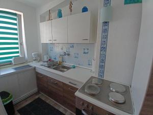 a kitchen with white cabinets and a sink at Ferienwohnung Nordsee mit E-Bike Verleih in Wilhelmshaven