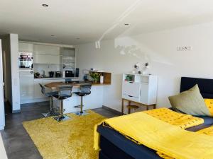 a bedroom with a bed and a kitchen with a table at Fewo Saur in Immenstaad am Bodensee