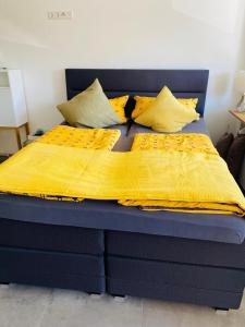 ein blaues Bett mit einer gelben Decke drauf in der Unterkunft Fewo Saur in Immenstaad am Bodensee