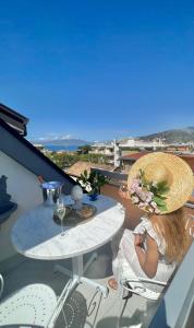 una donna seduta a un tavolo sul balcone di MAISON LADY CLAUDIA LUXURY ACCOMMODATION a Sorrento