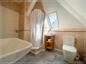 a bathroom with a white tub and a toilet at Saar-Apartments in Merzig +45 photos