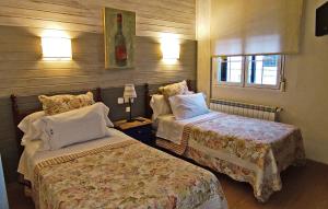 a hotel room with two beds and a window at Hostal Martin - Sanabria in Ribadelago