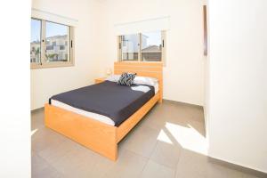 a bedroom with a bed and two windows at Bowker Apartment in Protaras +15 photos