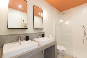 a bathroom with two sinks and a toilet at Casa Rosa Villa with Pool in Olhao Centre in Olhão