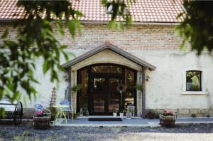 a brick building with a door and chairs and flowers at Lawendowa Stajnia in Lwówek Śląski