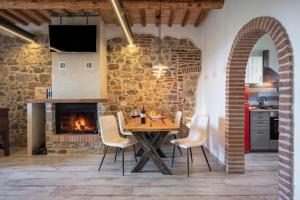 a kitchen and dining room with a table and a fireplace at Residenza Castello di Valli in Follonica