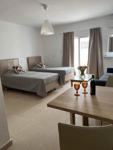 a living room with two beds and a table at Christothea Apartments in Ayia Napa