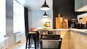 a kitchen with a stove and a counter with stools at Gelber Löwe - Ferienwohnung in der Erfurter Altstadt in Erfurt