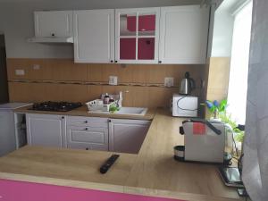 a kitchen with white cabinets and a counter top at Apartament "Przy Jeziorku" in Kętrzyn
