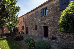 stary ceglany budynek z dziedzińcem przed nim w obiekcie Residenza Castello di Valli w mieście Follonica