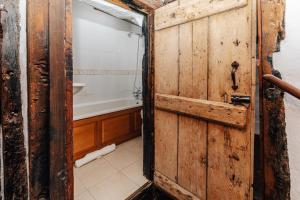 ein Badezimmer mit einer Holztür und einer Badewanne in der Unterkunft 1400 Cottage An enchanting unique stay in Henley on Thames + 29 Fotos