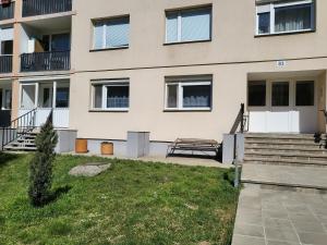 a building with a bench in front of it at Komló Szíve Apartman in Komló