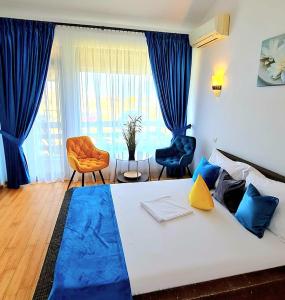 sypialnia z dużym białym łóżkiem z niebieskimi poduszkami w obiekcie Cirex Delta Club Sulina w mieście Sulina