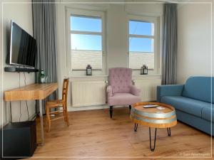 a living room with a couch and a chair and a table at Saar-Apartments in Merzig